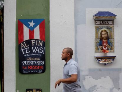 Un hombre camina junto a un letrero celebrando la dimisión del gobernador Ricardo Rosselló.