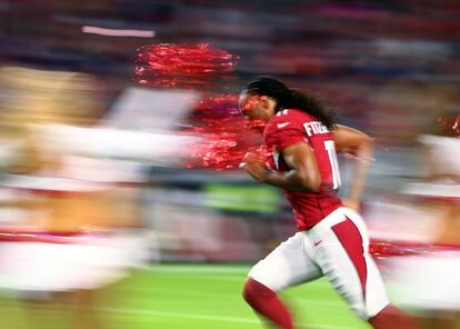 Un jugador de fútbol americano del Arizona Cardinal entra en el terreno de juego antes del partido contra los Baltimore Ravens en Glendale, Arizona (EE UU).