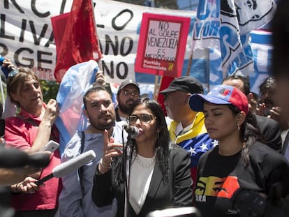 A chanceler da Venezuela, Delcy Rodríguez, fala em Buenos Aires na frente do Ministério das Relações Exteriores rodeada por manifestantes.