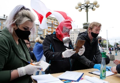 Activistas con guantes y mascarilla recogen firmas para los candidatos opositores en Minsk, el pasado domingo.