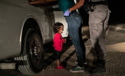 Una niña hondureña llora mientras su madre es registrada por un policía estadounidense de fronteras en Texas, en 2019.