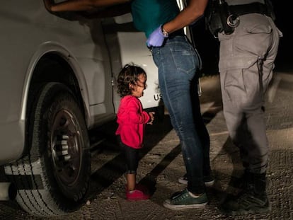 Una niña hondureña llora mientras su madre es registrada por un policía estadounidense de fronteras en Texas, en 2019.