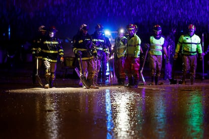 Integrantes de la Unidad Militar de Emergencia (UME)  caminan con palas en medio de la lluvia en Paiporta (Valencia), este domingo.