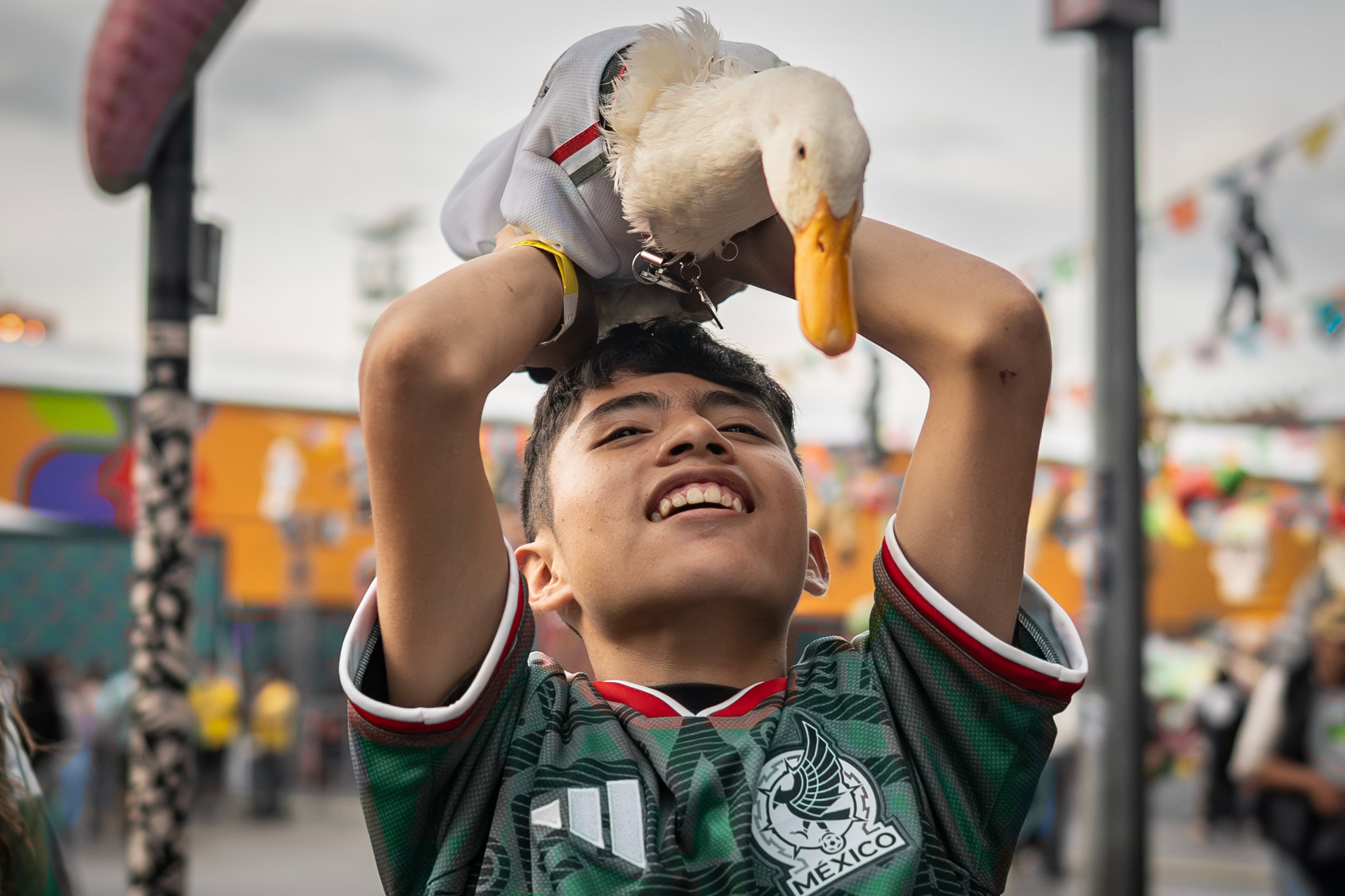 Cristian Gómez sostiene a Merlín en el Fan Fest de Ciudad de México.