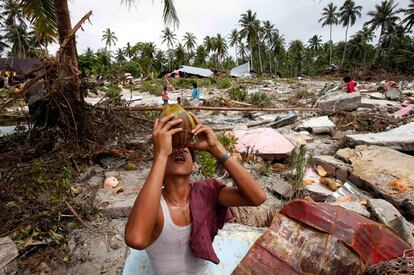 Un superviviente bebe agua de un coco entre los restos de las viviendas destruidas por el maremoto en Pororogat, en las islas Mentawai al oeste de Sumatra.