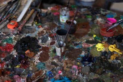 Detall de les pintures i altre objectes sobre una mesa del taller de Pere Llobera.