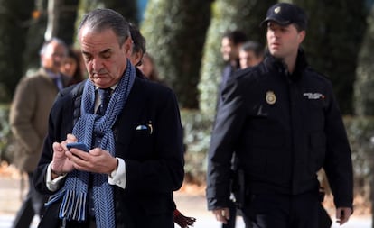 Mario Conde consulta su teléfono móvil a la salida de la Audiencia Nacional, en Madrid.