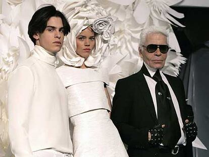 Karl Lagerfeld posa con dos de sus creaciones presentadas ayer en París.