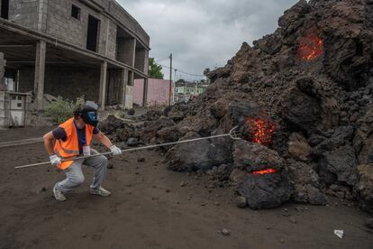 Un técnico del Instituto Volcanológico de Canarias (INVOLCAN) extrae una muestra de roca volcánica procedente de la colada de lava a su llegada a la localidad de Todoque, este miércoles.