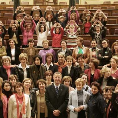 La vicepresidenta del Gobierno, María Teresa Fernández de la Vega, a la izquierda del ministro de Trabajo, Jesús Caldera, junto a diputadas y representantes de asociaciones de mujeres.