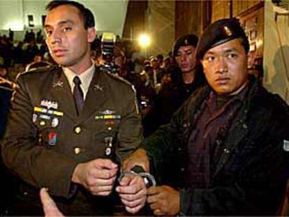 La policía militar escolta al capitán Byron Oliva, uno de los cuatro condenados, en los juzgados de Guatemala.