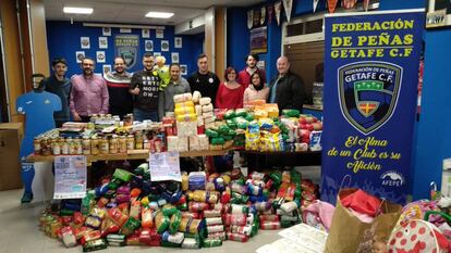 Peñistas del Getafe CF posan con parte de los alimentos recogidos durante su campaña navideña junto a Aficiones Unidas.