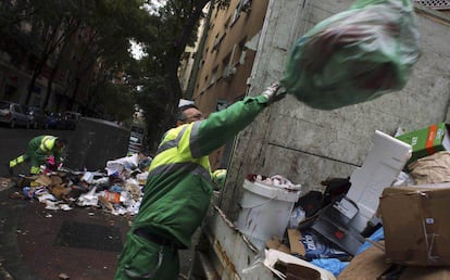 Un trabajador del servicio de limpieza viaria de Madrid limpia los restos de la huelga de basuras de 2014.