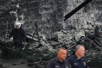 An investigator surveys the aftermath of an elevated section of Interstate 95 that collapsed