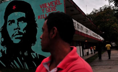 Un alumno pasa frente a un mural del Che Guevara en la escuela de Ayotzinapa, donde los alumnos desaparecidos estudiaban para convertirse en maestro en zonas rurales. En el centro se reivindica la lucha obrera y campesina y los jóvenes, procedentes de familias de bajos recursos, reciben una formación de tradición marxista.