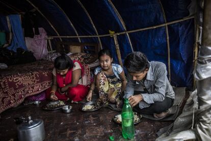 Los refugiados sobreviven con los alimentos que llegan de vez en cuando de diferentes partes y se ayudan los unos a los otros para conseguir cualquier cosa que les haga su vida un poco más cómoda. En la imagen, miembros de la famila Baniya se reúnen para comer todos juntos en una de las tiendas del campamento.