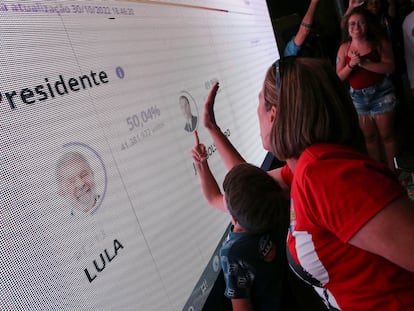 Simpatizantes de Lula da Silva siguen el conteo de los votos, este domingo en Brasilia.