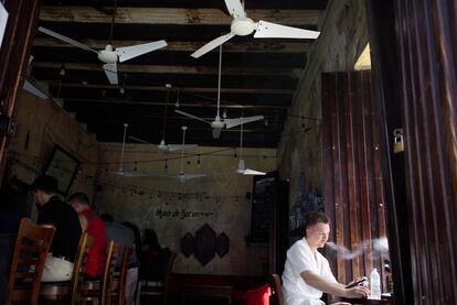 Un hombre fuma en una cafetería sin luz, en San Juan.