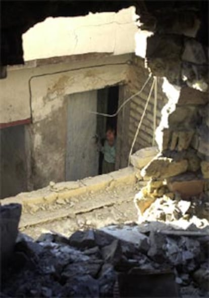 Un ni?o observa el agujero que ha dejado en un edificio un misil lanzado en el barrio bagdad de Sadr City.