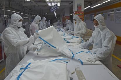 Los trabajadores de Beximco Textiles producen equipos de protección contra el coronavirus, en Savar (Bangladés). Enfrentándose a la ruina al colapsar los pedidos de las empresas occidentales, muchas fábricas de ropa del país han recibido órdenes de fabricar mascarillas, guantes y batas de protección para la exportación.