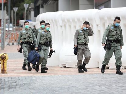 Agentes de seguridad protegidos con mascarillas en Hong Kong. 