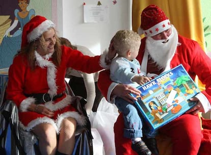 Uno de los niños que vive en el centro penitenciario Madrid VI recibe un regalo de Papá y Mamá Noel.