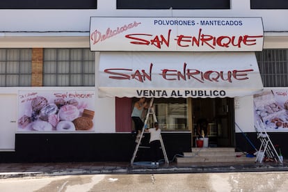 Varias mujeres preparan el exterior de un comercio de mantecados en Estepa, Sevilla.