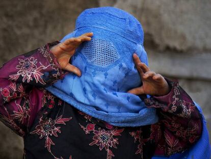 Uma menina afegã tenta ver através de sua burca.
