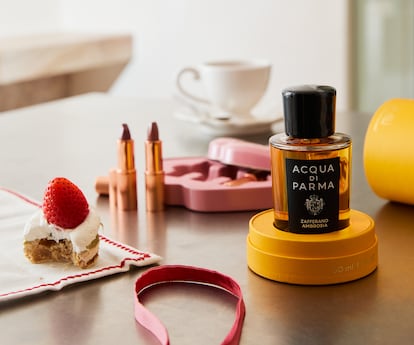 Al fondo, kit con tres labiales en formato viaje Hollywood Iconic Mini Lip Trio de CHARLOTTE TILBURY; y delante, Zafferano Ambrosia Extrait de Parfum de ACQUA DI PARMA, que recoge la opulencia del azafrán con una concentración del 30% de aceite de perfume puro.