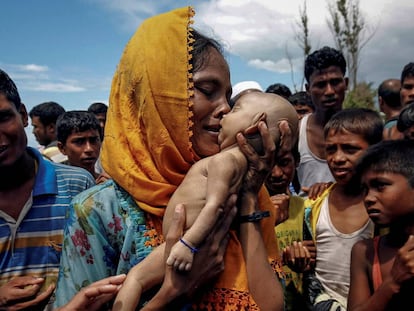 Uma mulher chora enquanto segura seu filho que morreu afogado quando um bote em que estavam virou antes de chegar a Bangladesh.