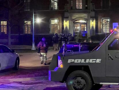Armed police officers with weapons drawn rush into Phillips Hall on the campus of Michigan State University, in East Lansing, Mich., as authorities respond to reports of shootings, late Monday, Feb. 13, 2023.