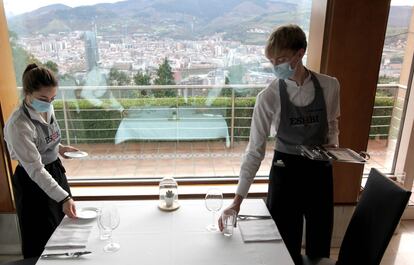 Dos alumnas preparan el servicio en el comedor de Artxanda con vistas a Bilbao.