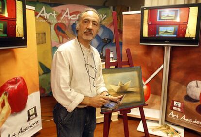 El artista José Ibarrola, ayer, en Bilbao ante uno de sus cuadros con la consola en las manos.