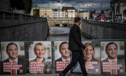 Un hombre camina junto a los carteles electorales de los ministros Stefan Loefven, Magdalena Andersson y Margot Wallstrom.