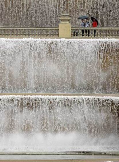 Unos turistas toman unas fotografías en Barcelona, que registra las mayores precipitaciones de los últimos años.