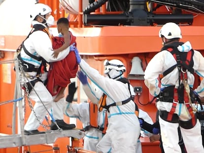 Un miembro de la Cruz Roja ayuda a bajar del barco a un niño migrante en el puerto de Arguineguín (Gran Canaria) el pasado 17 de marzo.