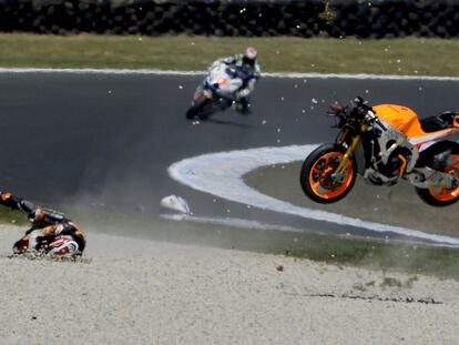 Marc Márquez rueda por el suelo, con su moto en el aire, tras su choque con Ratthapark Wilairot.