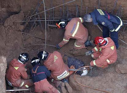 Los bomberos, ayer, en el momento de extraer el cuerpo del obrero muerto al derrumbarse una construcción en Picanya.