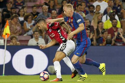 El centrocampista del Deportivo Alavés Edgar Méndez lucha con el defensa francés del FC Barcelona Jérémy Mathieu.