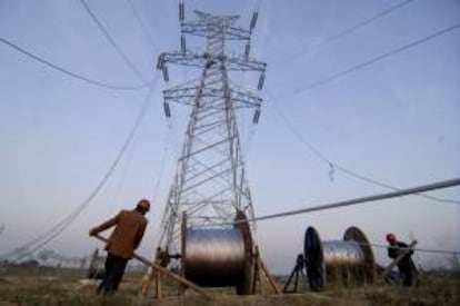 Trabajadores colocan una torre de electricidad de alto voltaje. EFE/Archivo