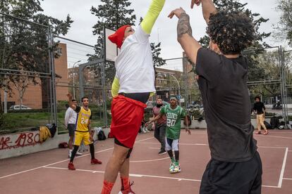 Los jugadores comienzan a llegar a las pistas de baloncesto entorno a las 11 de la mañana del sábado. Las historias vitales de los jóvenes son prácticamente un calco. Casi todos cuentan que las primeras en venir a España fueron sus madres, a trabajar en la hostelería o como limpiadoras, y después de un tiempo acabaron viniendo ellos como parte de un proceso de reagrupamiento familiar. En la imagen, un partido amistoso en una cancha del barrio de Orcasitas donde se reúnen para preparar la liga oficial.
