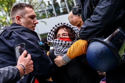 Agentes de policía detienen a una manifestante, mientras desmantelan un campamento propalestino establecido en la Universidad Libre de Berlín, este martes.