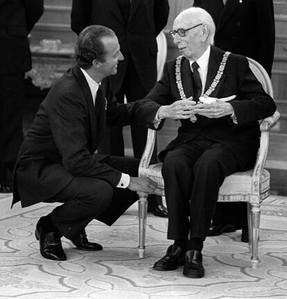 El rey Juan Carlos conversa, agachado, con el escritor y académico José María Pemán, tras imponerle el gran collar de la Orden Toisón de Oro, en un acto en el palacio de La Zarzuela el 19 de mayo de 1981, dos meses antes de su muerte.Fue alabado como dramaturgo y articulista en vida, pero cayó en el olvido tras su falecimiento. Como autor de teatro tuvo grandes éxitos a mediados del siglo pasado, como 'El divino impaciente' y 'Los tres etcéteras de Don Simón'.