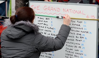 Los apostantes muestran sus probabilidades antes de la carrera Grand National de caballos en el hipódromo de Aintree en Liverpool, noroeste de Inglaterra.
