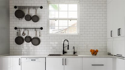 Una cocina minimalista con azulejos blancos.