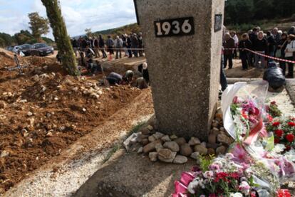 Familiares de fusilados dejan flores en la fosa común exhumada ayer en La Pedraja (Burgos).