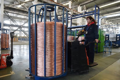 Una empleada transporta una bobina de cable de cobre en la provincia china de Jiangsu.