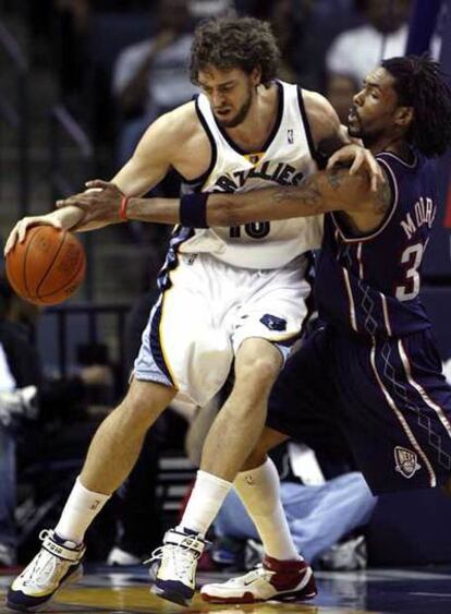 El jugador español de los Grizzlies de Memphis, Pau Gasol , protege el balón ante la presión de Mikki Moore, de los Nets de Nueva Jersey.