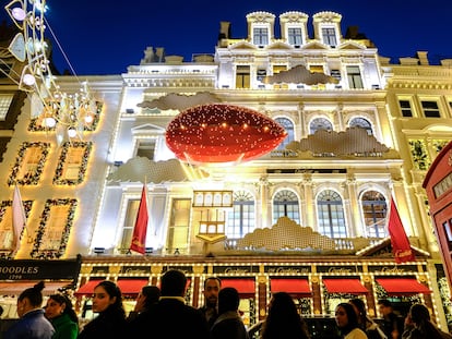 La tienda de Cartier engalanada de Navidad. Visitantes y compradores admiran la iluminación navideña en New Bond Street y Old Bond Street.