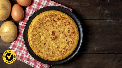 Una tortilla en un plato con unas patatas y unos huevos a su lado